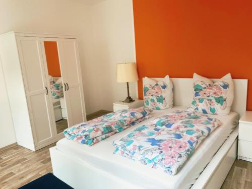 ein Schlafzimmer mit einem weißen Bett mit orangefarbenen Wänden in der Unterkunft Ferienwohnung Klosterstrasse mit 2 Schlafzimmern in Annaberg-Buchholz