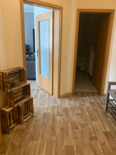 ein Wohnzimmer mit Holzboden und einer Tür in der Unterkunft Ferienwohnung Klosterstrasse mit 2 Schlafzimmern in Annaberg-Buchholz