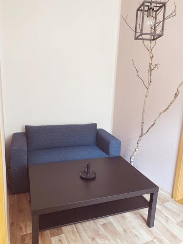 a living room with a blue couch and a coffee table at Ferienwohnung Klosterstrasse mit 2 Schlafzimmern in Annaberg-Buchholz