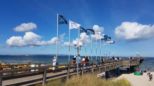 a pier with flags and people on the beach at Ferienhaus Meeresrauschen in Binz