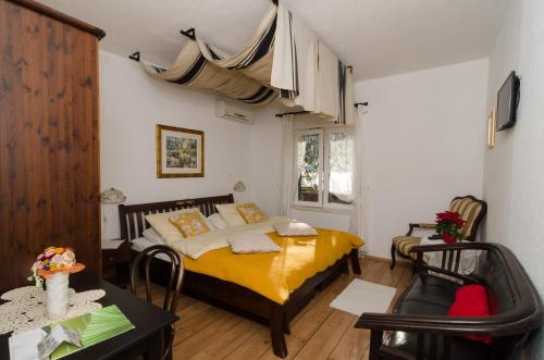 a bedroom with a yellow bed and a table and chairs at B&B Villa Dubrovnik Garden in Dubrovnik