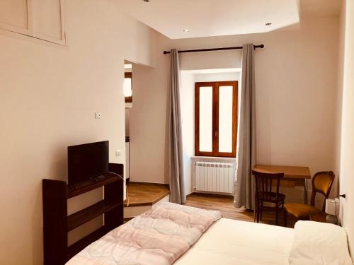 a bedroom with a bed and a tv and a table at LeonessHouse in Leonessa