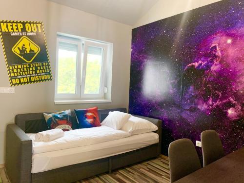 a room with a bed with a galaxy mural on the wall at Mese Panzió Zalakaros in Zalakaros