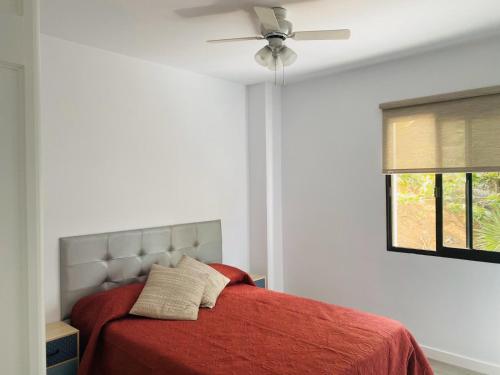 sypialnia z łóżkiem i wentylatorem sufitowym w obiekcie Apartamento Playa La Arena w mieście Puerto de Santiago