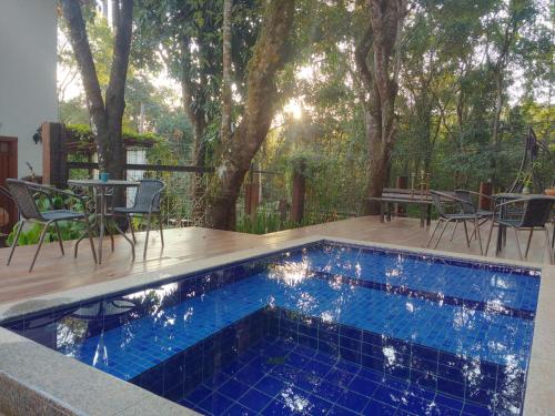 uma piscina num deque com uma mesa e cadeiras em Villa Rica Pousada Boutique em Brumadinho