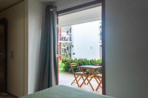 Pokój z drzwiami wychodzącymi na patio ze stołem w obiekcie Apartamento no Taiba Beach Resort w mieście Taíba