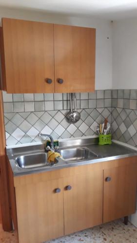 La cuisine est équipée d'un évier et de placards en bois. dans l'établissement Casa vacanza a Campolieto, à Campolieto