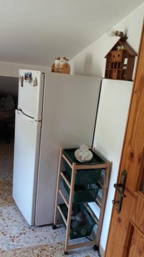 um frigorífico numa cozinha com uma prateleira ao lado em Casa vacanza a Campolieto em Campolieto