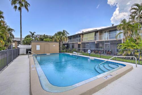 a swimming pool in front of a building with palm trees at Condo with Pool Access Less Than 4 Miles to Siesta Key Beach in Sarasota