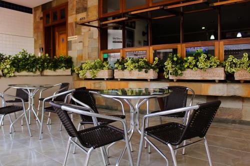 a table and chairs in a restaurant with plants at Hotel Garrafão - Rua Principal de Boituva in Boituva