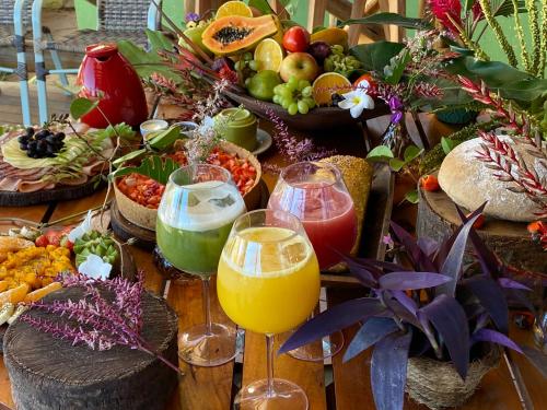 a table topped with glasses of orange juice and fruit at Carapitangui Pousada in Barra Grande