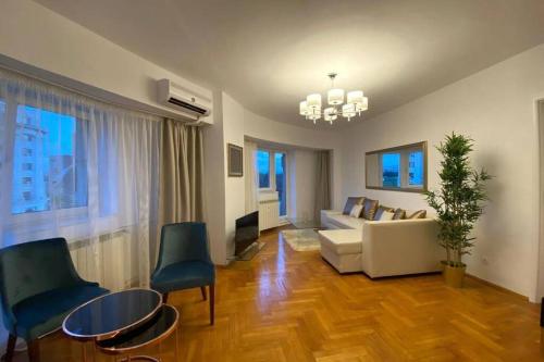 a living room with a couch and a table and chairs at New Luxury Flat in front of the Parliament at Unirii in Bucharest