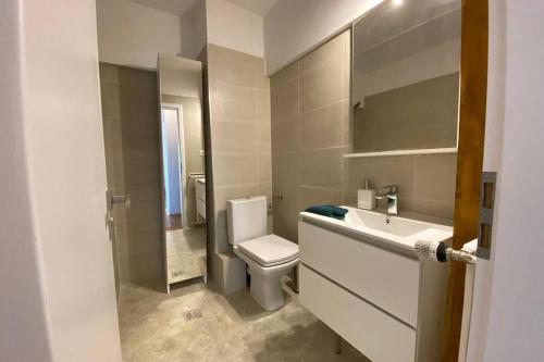 a white bathroom with a toilet and a sink at New Luxury Flat in front of the Parliament at Unirii in Bucharest