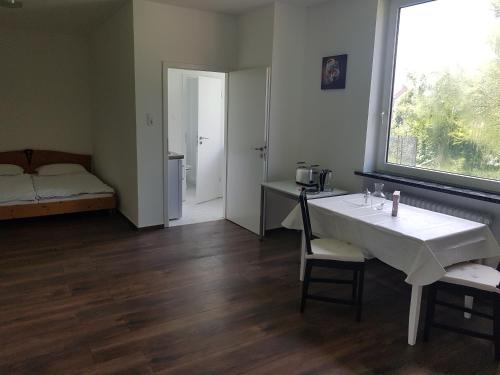 a room with a table and a bed and a window at Apartments am Kanal in Emden