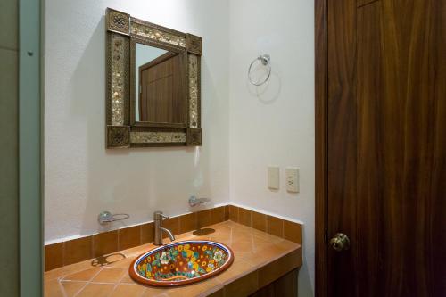een badkamer met een wastafel met een spiegel bij Hotel Hortencia in Puerto Vallarta