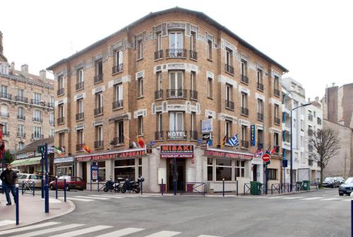 een groot bakstenen gebouw op de hoek van een straat bij Hotel Victor Hugo in Clamart