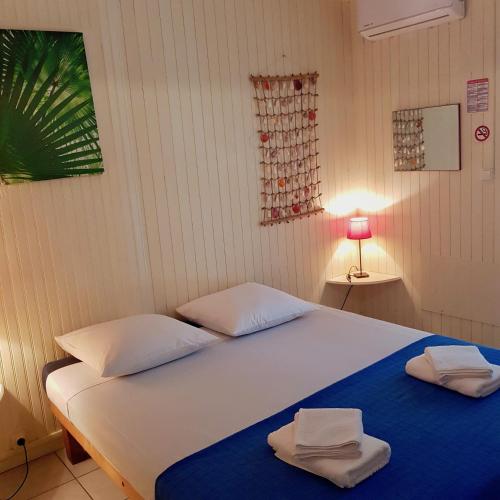 a bedroom with a bed with two towels on it at La plage de Petit-Havre in Le Gosier