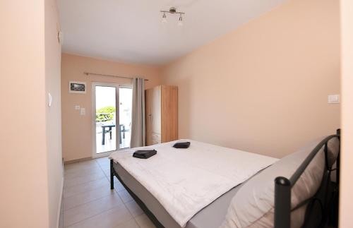 een slaapkamer met een bed met twee zwarte schoenen erop bij Happy Days Home Apartment und Studio/Penthouse in Ialyssos