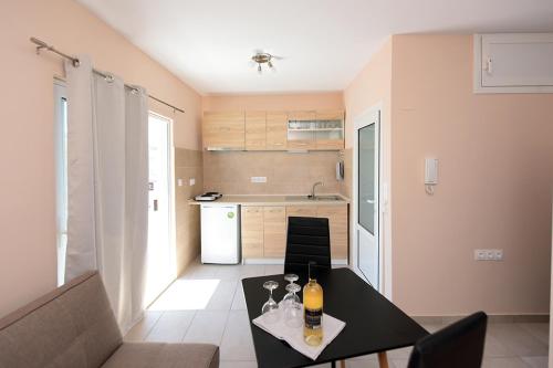 een woonkamer met een tafel en een keuken bij Happy Days Home Apartment und Studio/Penthouse in Ialyssos