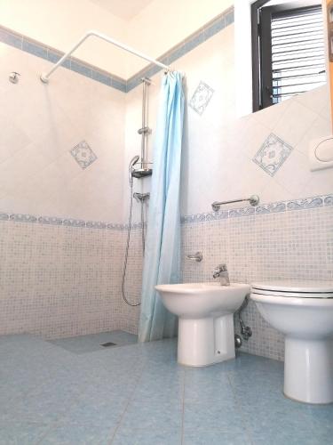 a bathroom with a toilet and a sink and a shower at villa Lina in Capilungo