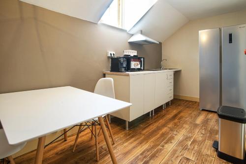 a kitchen with a white table and a refrigerator at Palacete Suite Aveiro in Aveiro