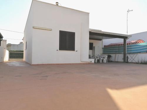 a white building with tables and chairs on a patio at villa Lina in Capilungo