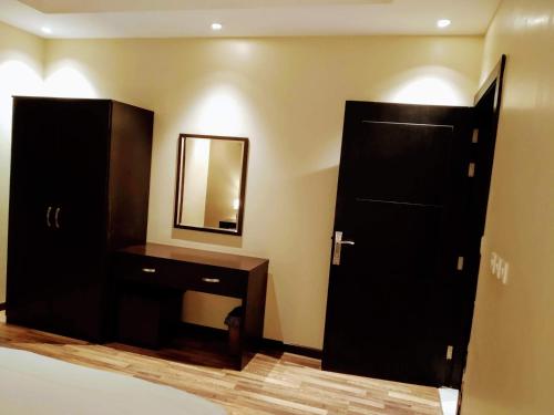 baño con armario negro, lavabo y espejo en شقق درر رامه للشقق المخدومة 6, en Riad