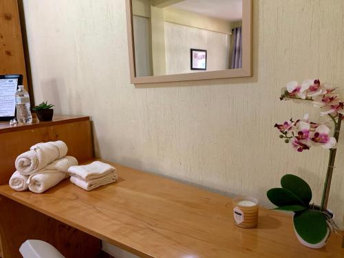 a bathroom with towels on a wooden counter with a mirror at Hotel-Villas JABEL TINAMIT in Panajachel