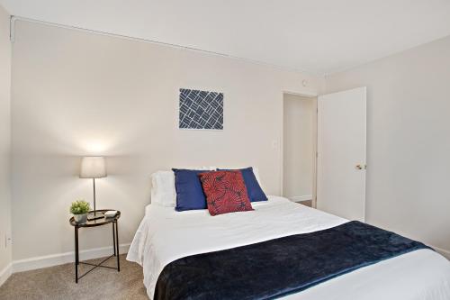 a bedroom with a white bed with a black blanket at Vibrant Pad next to ForestPark/BJC/WashU in Maryland Heights