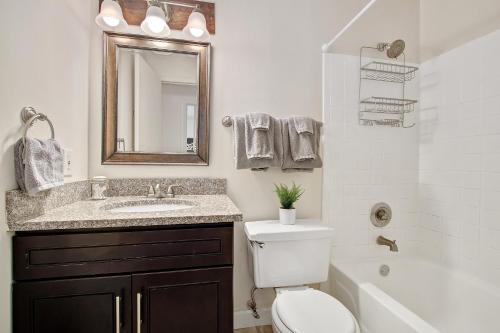 a bathroom with a sink and a toilet and a mirror at Vibrant Pad next to ForestPark/BJC/WashU in Maryland Heights