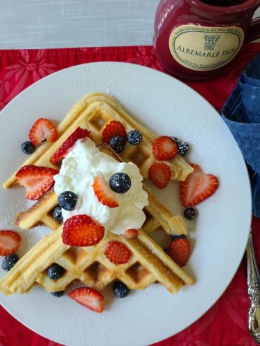 une assiette de gaufres avec des baies et de la crème fouettée dans l'établissement Albemarle Inn - Asheville, à Asheville