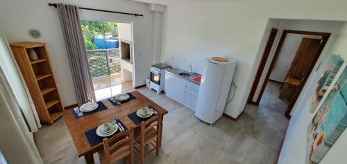 a small kitchen with a table and a refrigerator at Morada da Figueira in Bombinhas