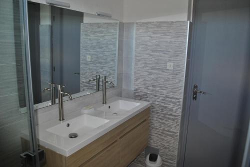 uma casa de banho com um lavatório branco e um espelho. em Mas de la Vignassa em Le Soler