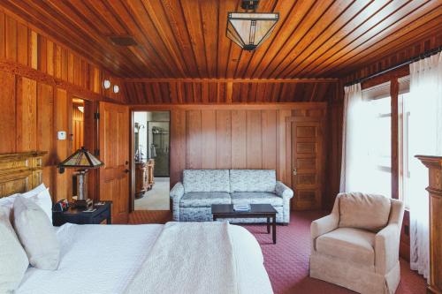 1 dormitorio con 1 cama, 1 sofá y 1 silla en Noyo Harbor Inn en Fort Bragg