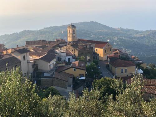 a village with a clock tower on a hill at Sdraiati Pollica - Apartments - Bed & Breakfast in Pollica