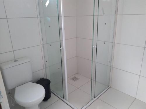 een badkamer met een toilet en een glazen douche bij Apartamento em Guaramiranga in Guaramiranga