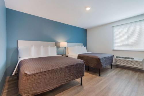a hotel room with two beds and a window at WoodSpring Suites Tamarac in Tamarac