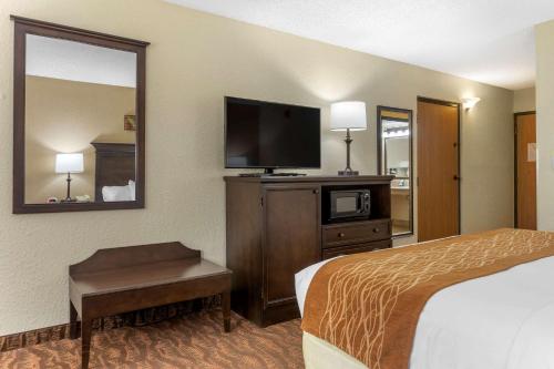 a hotel room with a bed and a flat screen tv at Comfort Inn at Thousand Hills in Branson