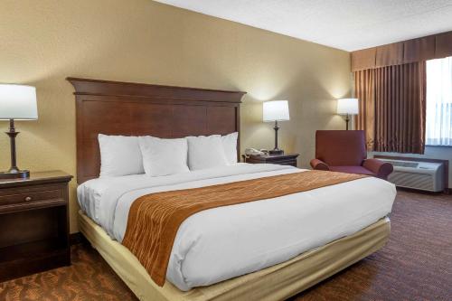 a hotel room with a large bed and a chair at Comfort Inn at Thousand Hills in Branson