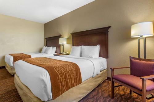 a hotel room with two beds and a chair at Comfort Inn & Suites Branson Meadows in Branson