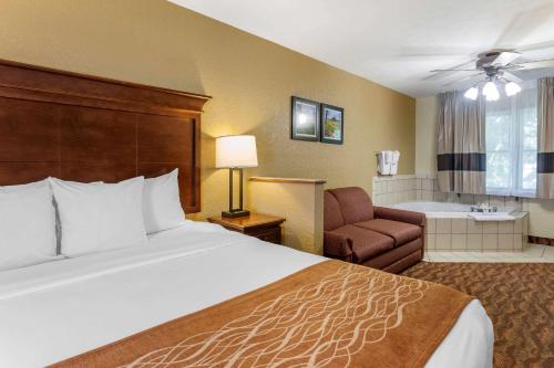 a hotel room with a bed and a bath tub at Comfort Inn & Suites Branson Meadows in Branson