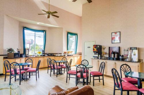 a restaurant with tables and chairs and a kitchen at Econo Lodge Inn & Suites Gulfport Airport in Gulfport