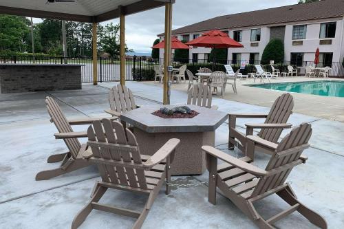 a patio with a table and chairs and a pool at Sleep Inn & Suites Spring Lake - Fayetteville Near Fort Liberty in Spring Lake