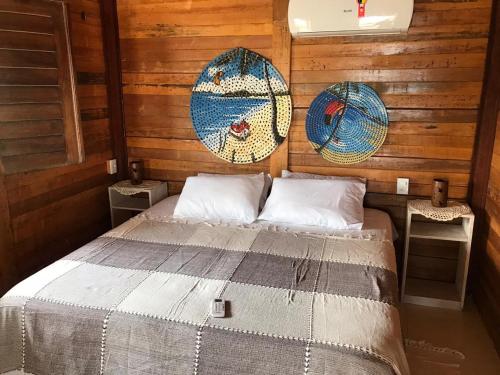 a bedroom with a bed in a wooden cabin at Pousada Portal do Kite in Tatajuba
