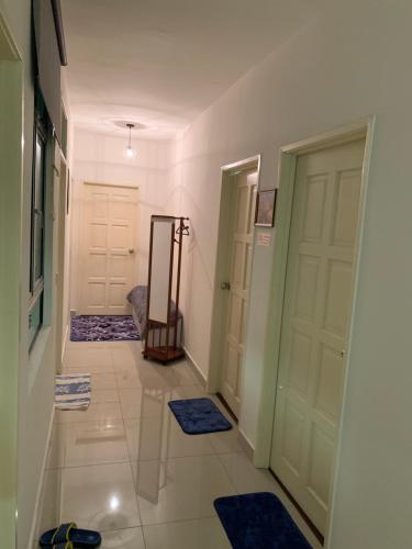 a hallway with two doors and blue rugs on the floor at TR Penang House for Large Family Getaways in Bayan Lepas
