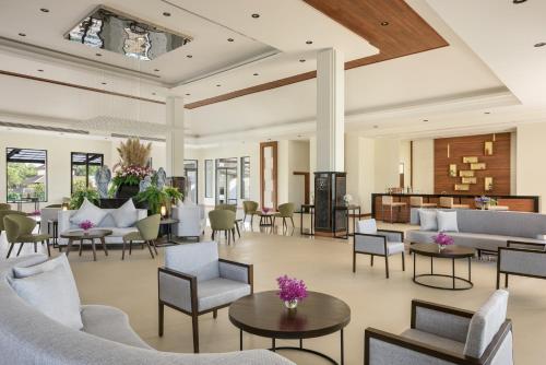 a lobby with couches and tables and chairs at Chainarai Riverside - SHA Plus Certified in Chiang Rai