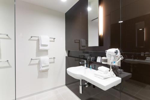 a bathroom with a white sink and a mirror at Great Southern Hotel Melbourne in Melbourne