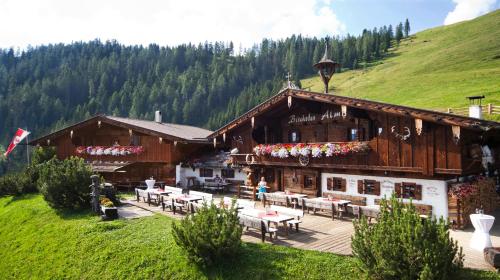 a building with tables and chairs in front of it at Luxus Chalet Bischofer- Bergwelt in Alpbach