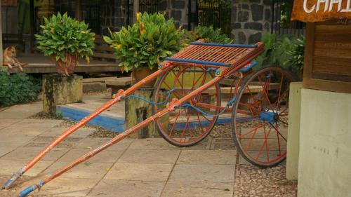 una bicicleta naranja estacionada frente a un edificio en Green's Guest House en Auroville