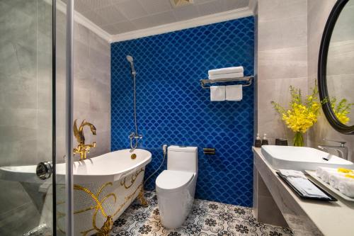 a bathroom with a tub and a toilet and a sink at Ha Long Essence Hotel in Ha Long